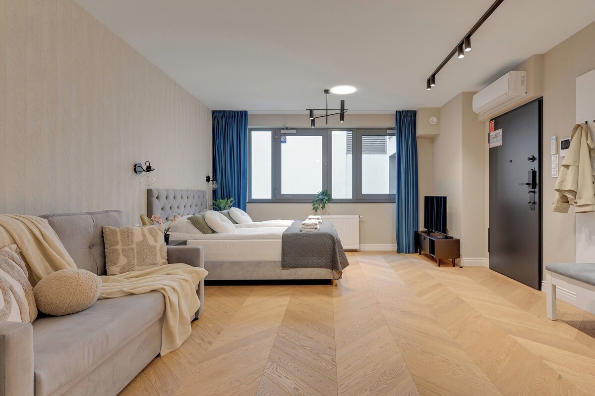 Una habitación de hotel moderna con cama, sofá, televisión y armario.