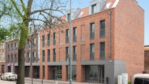 A modern brick building with multiple windows and a flat roof.