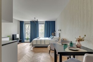 Quarto de hotel moderno com cama, mesa de jantar e televisão.