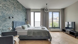 A modern bedroom with a large bed, a flat-screen TV, and a view of the city.