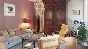 Una sala de estar con sofá, sillón, mesa de centro y un mueble de madera grande.