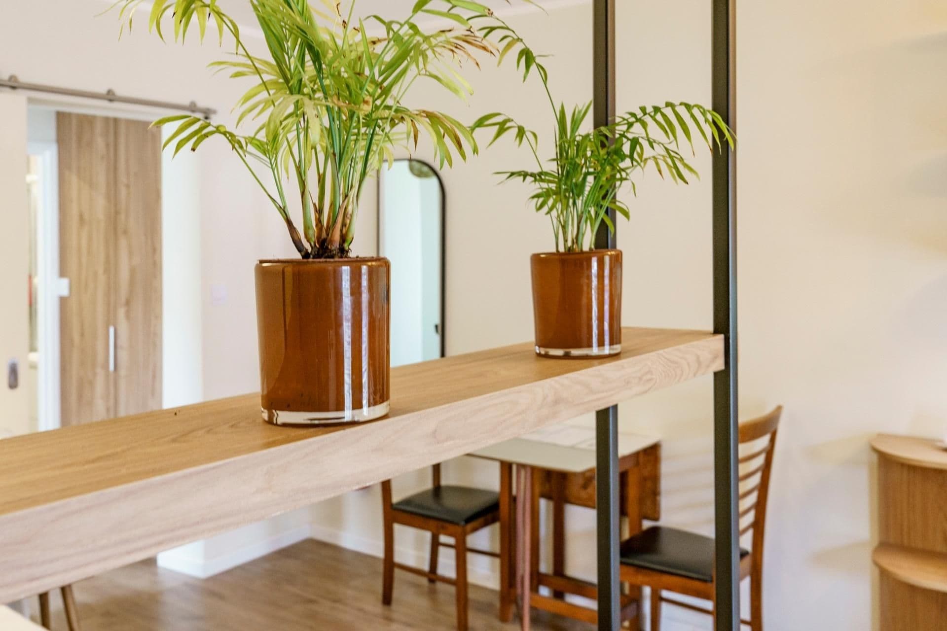 Uno scaffale in legno con due piante in vaso.