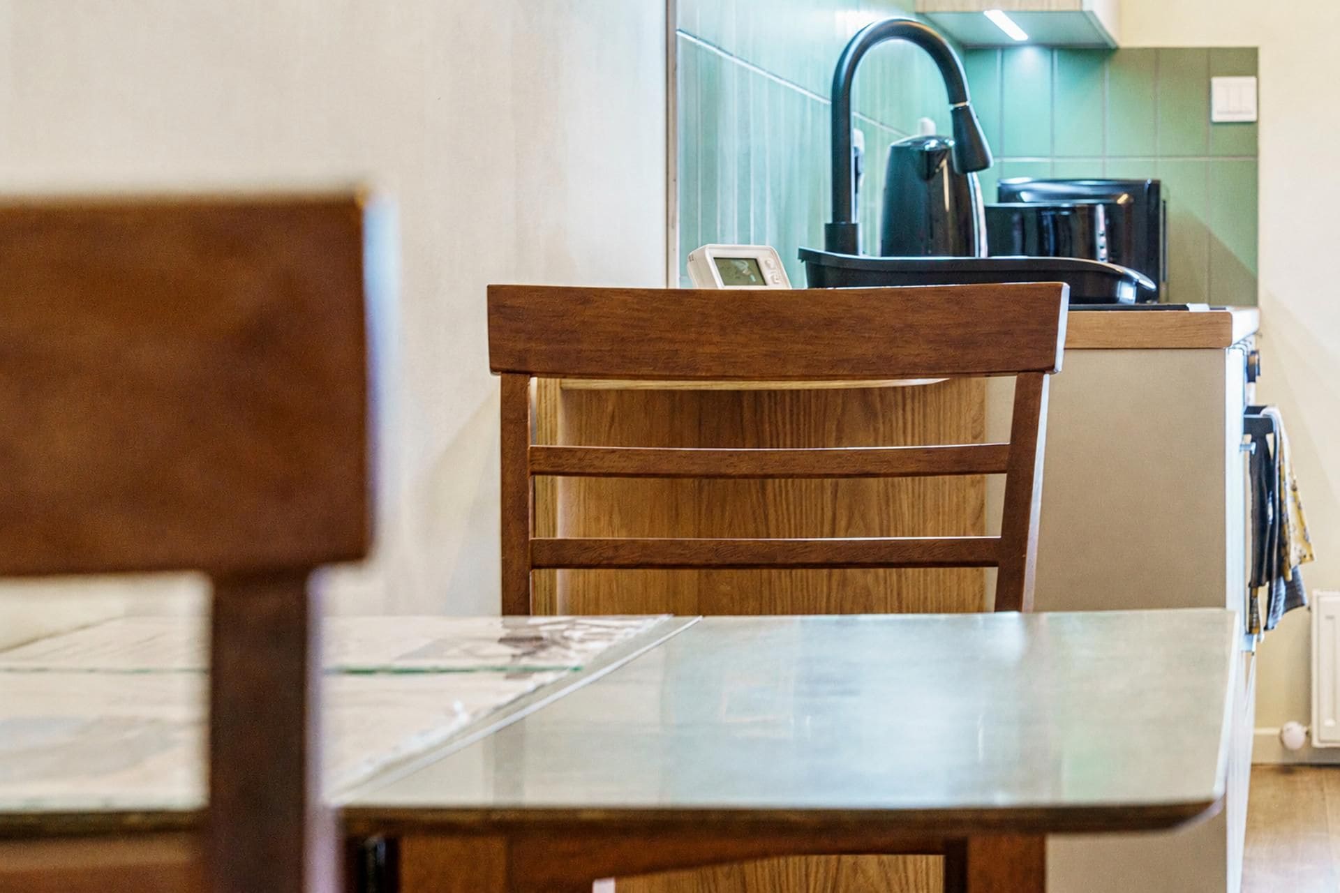 A wooden chair with a metal table in a kitchen area.