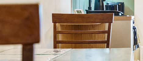A wooden chair with a metal table in a kitchen area.