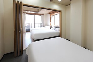 A hotel room with two beds, a balcony, and a view of the city. - Sweetpad (Setagaya City)
