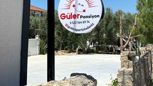 A sign for a property named 'Güler Pansiyon' with contact information. - Sönmez Güler Pansiyon Ölüdeniz (Muğla)