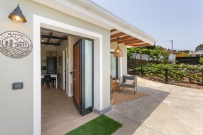 A modern villa with a covered outdoor seating area, a dining space, and a visible kitchen. -  'El Llano' with Sea View, Private Pool and Wi-Fi (La Orotava)