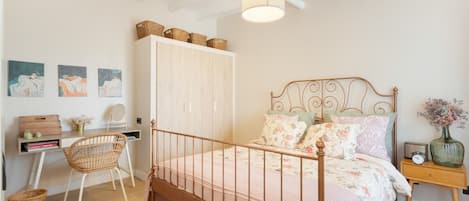 Un dormitorio con cama, escritorio, silla y armario.