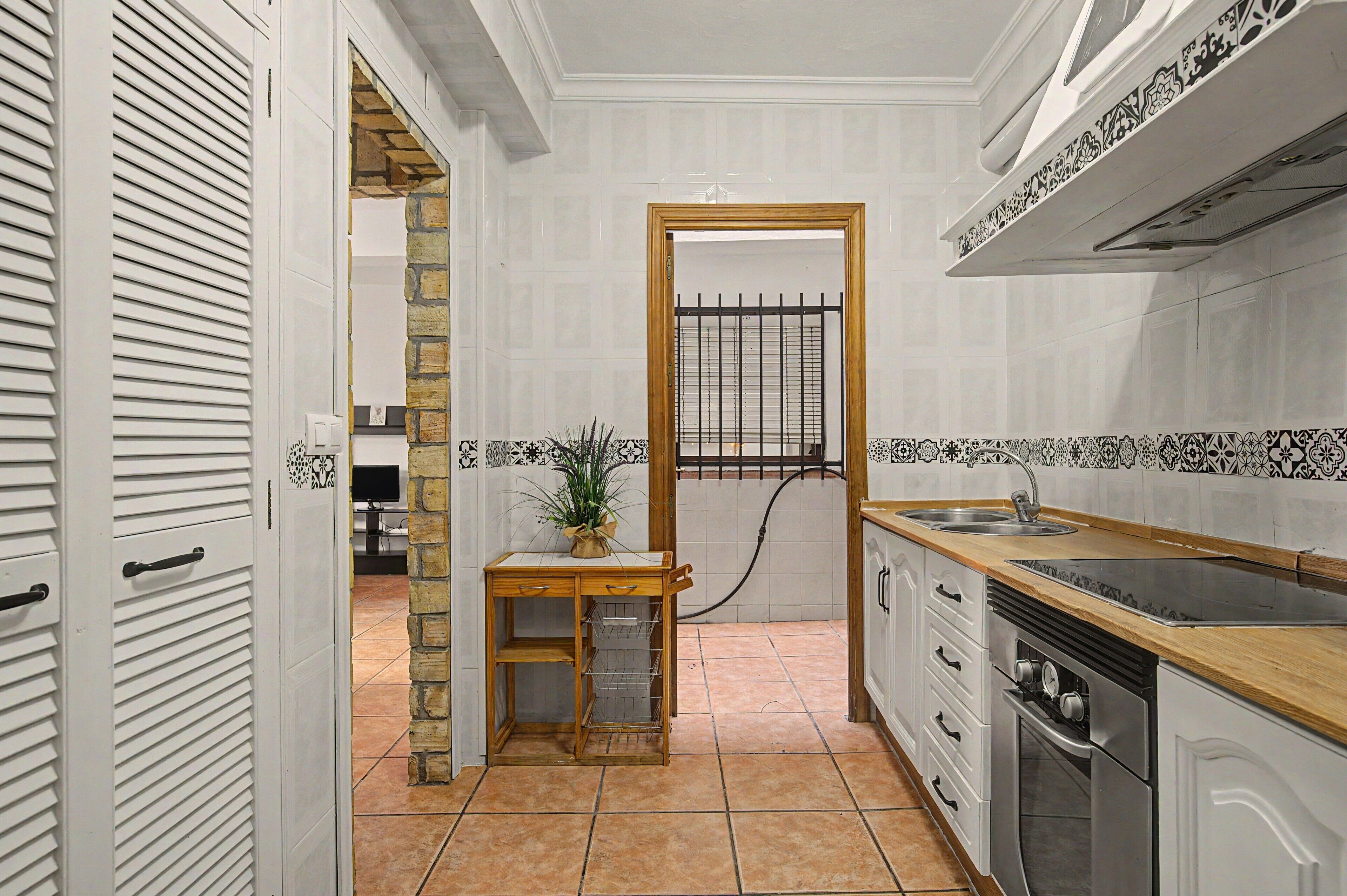 A compact kitchen with a wooden countertop, a sink, and a stove.