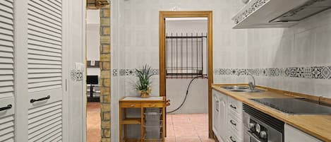 A compact kitchen with a wooden countertop, a sink, and a stove.