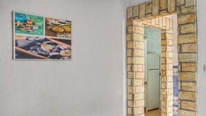 Un corridoio con un arco in mattoni che conduce a una stanza.