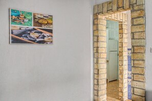 Ein Korridor mit einem Ziegelbogen, der in einen Raum führt.