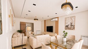A modern living room with a glass dining table, beige sofas, and a chandelier. - Magnifique 4 pièces à Constantine (Constantine)