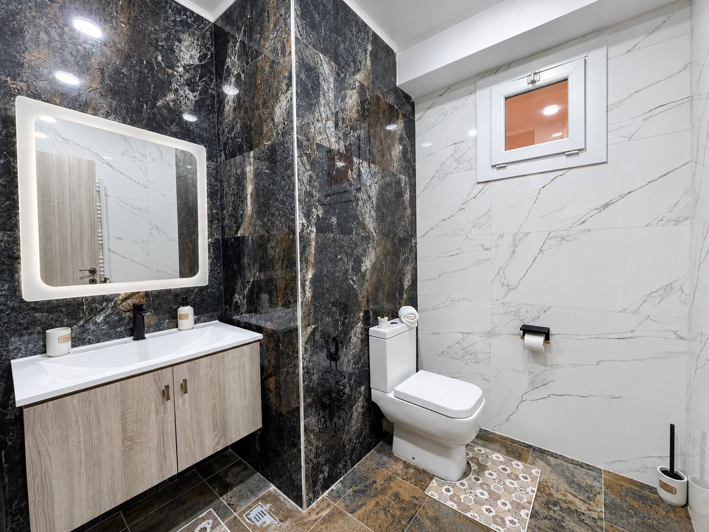 Ein Badezimmer mit Marmorwaschtisch, Toilette und Spiegel.