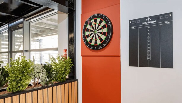 A dartboard mounted on a wall with a scoreboard beside it. - Student Only Clarence Dock (Leeds)