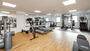 A gym with various exercise equipment, including treadmills, a stationary bike, and weight machines. - Student Only Clarence Dock (Leeds)