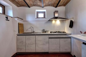 Una cocina con una isla central, estufa a gas, pileta y una ventana sobre la encimera.