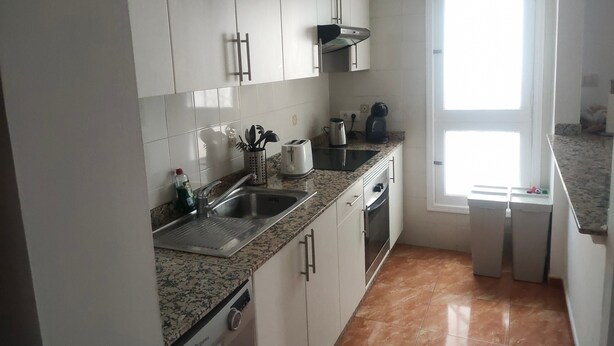 A kitchen with white cabinets, a stainless steel sink, a toaster, and a coffee maker. - Casa Princesa, cerca de la playa grande de Puerto del Carmen  (Tías)