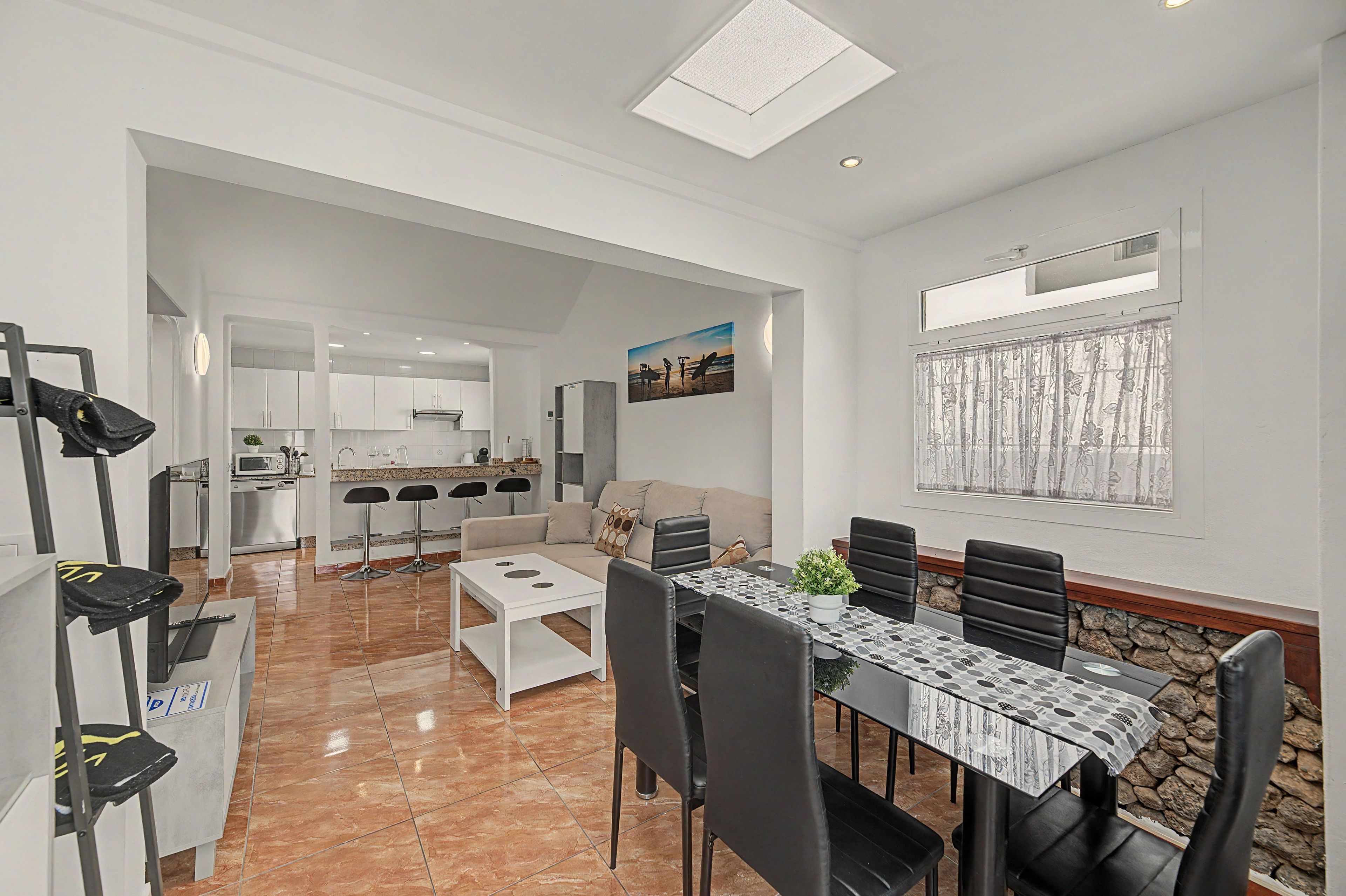 A modern living space with a dining area, kitchen, and a view of the outdoors.
