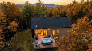 A modern house with a hot tub on the deck, surrounded by trees. - Confort Scandinave with Private spa & BBQ , Kéroul (Saint-Côme)