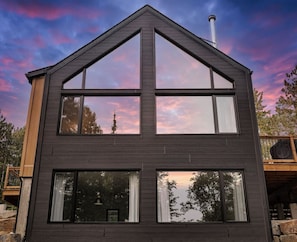 A modern two-story building with large windows and a prominent roofline. - Confort Scandinave with Private spa & BBQ , Kéroul (Saint-Côme)