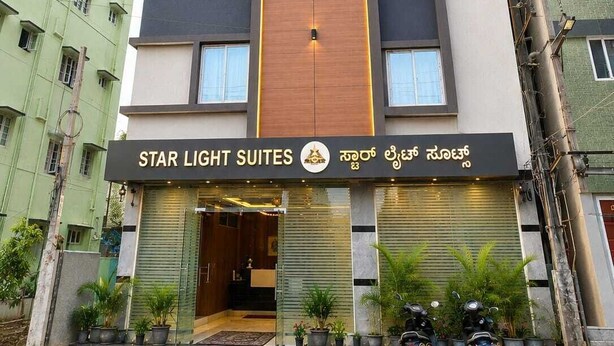 Een meerlaags hotel met een opvallend houten paneel en een bordje waarop 'Star Light Suites' staat.