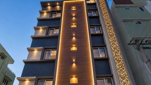 Een hotel met een moderne gevel, meerdere verdiepingen en een bord met de tekst 'Star Light Suites'.