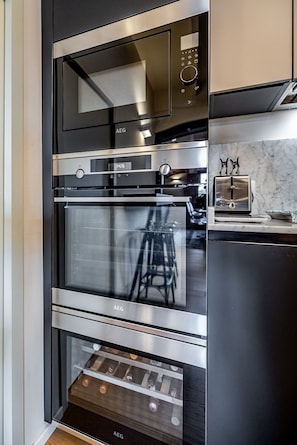 Een moderne keuken met een ingebouwde oven, een digitale klok en een broodrooster.