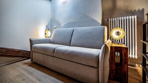 A modern living room with a sofa, a lamp, and a radiator. - Luxury Duomo apartment (Florence)
