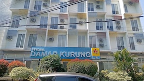 Un edificio de varios pisos con un letrero que dice 'Wisma Damai Kurung' y unidades de aire acondicionado en el exterior.