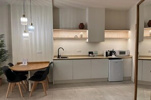 Une cuisine moderne avec un coin repas, comprenant un évier, un four à micro-ondes et des placards.