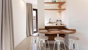 A compact kitchen with a central island, bar stools, and a window with curtains. - Standard double Mercado apartment with jacuzzi (Alicante)