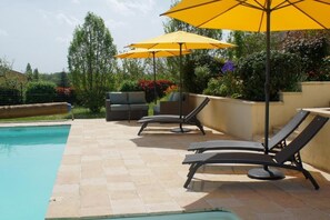 A poolside area with lounge chairs and umbrellas. - Chambres d'Hôtes La Bonne Voie (Lembras)