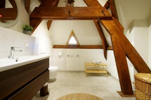 A bathroom with a wooden ceiling, a white sink, and a small wooden bench. - Chambres d'Hôtes La Bonne Voie (Lembras)