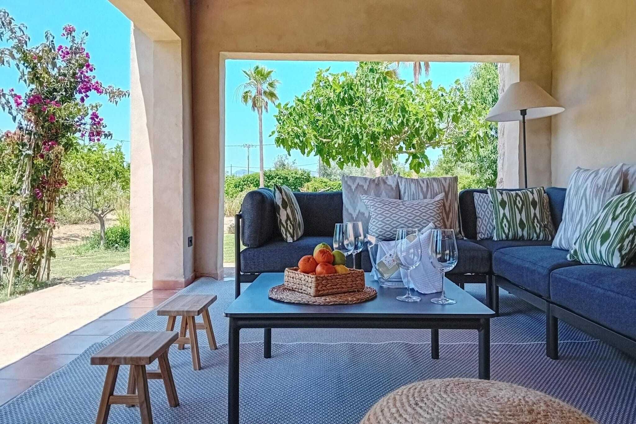 Un espacio exterior acogedor con un sofá, una mesa y un banco.