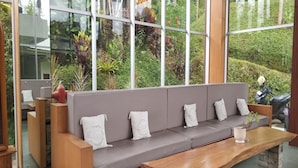 Um interior moderno com um sofá cinzento, almofadas brancas e um banco de madeira.