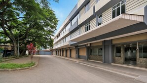 A multi-story building with a flat facade, large windows, and a covered walkway.