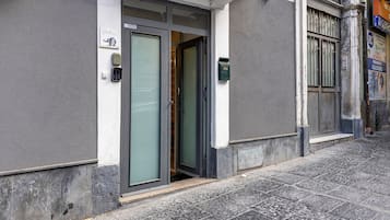 A building entrance with a door, a mailbox, and a window with bars.