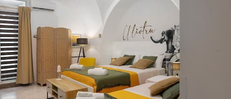A hotel room with two beds, a large mirror, and a decorative elephant sculpture.