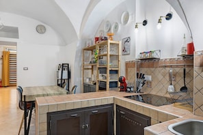 Eine Küche mit integrierter Kochinsel, einem Essbereich und einem Wohnbereich mit Kamin.