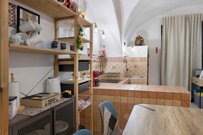 Een keuken met houten planken, een koffieapparaat en een betegelde achterwand.