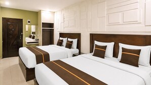 Quarto de hotel com duas camas, um guarda-roupa, um espelho e uma porta.