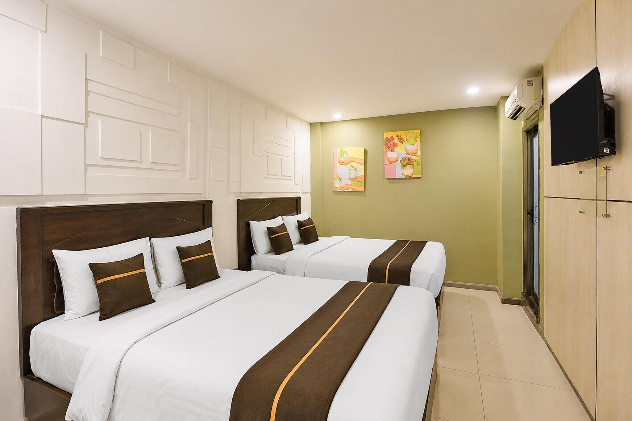 Habitación de hotel con dos camas, televisión y un cuadro en la pared.