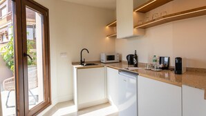 Una cocina compacta con microondas, cafetera y lavavajillas.