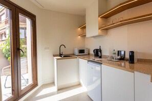 Eine kleine Küche mit Mikrowelle, Kaffeemaschine und Geschirrspüler.