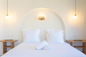 A hotel room with a large bed, two bedside tables, a wall-mounted light fixture, and a small shelf on each table. - Apartment in Alicante (Alicante)