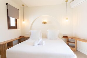 A hotel room with a bed, bedside tables, a wall-mounted light fixture, and a window. - Apartment in Alicante (Alicante)