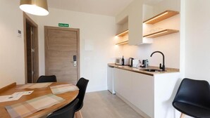 Una cocina moderna con microondas integrado, un fregadero y una puerta de madera con la inscripción 'SALIDA'.