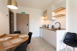 Eine moderne Küche mit integriertem Mikrowellenherd, einer Spüle und einer Holztür mit der Aufschrift 'SALIDA'.