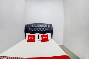 A single bed with a white mattress and two red pillows with 'OYO' branding. - Hotel O Brayan | Cozy Single Room (Medan)